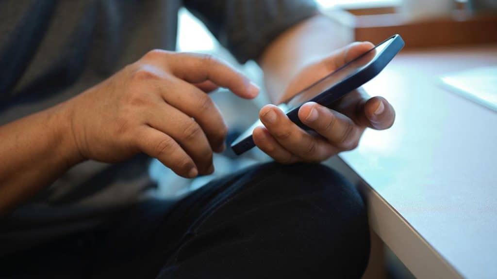 A person using a smartphone at a desk.