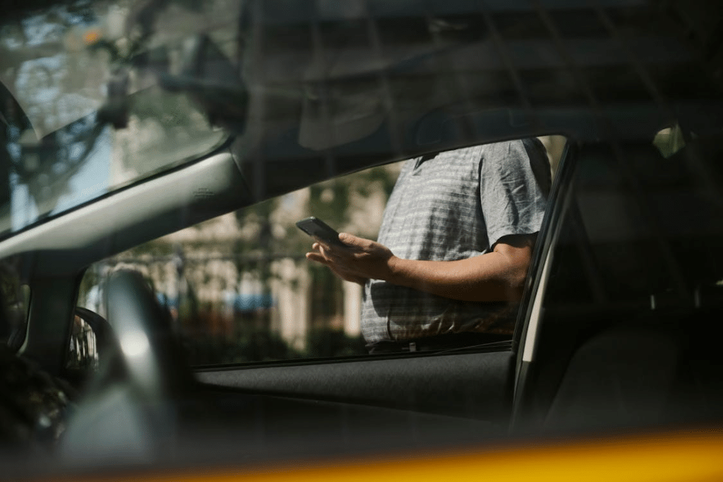 A man texting outside the car