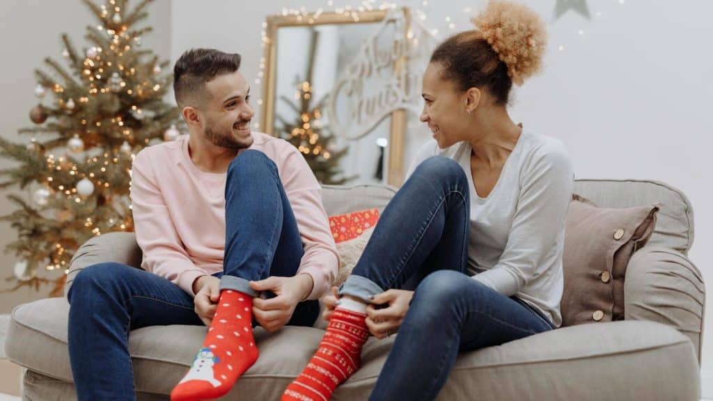 A couple wearing Christmas socks.