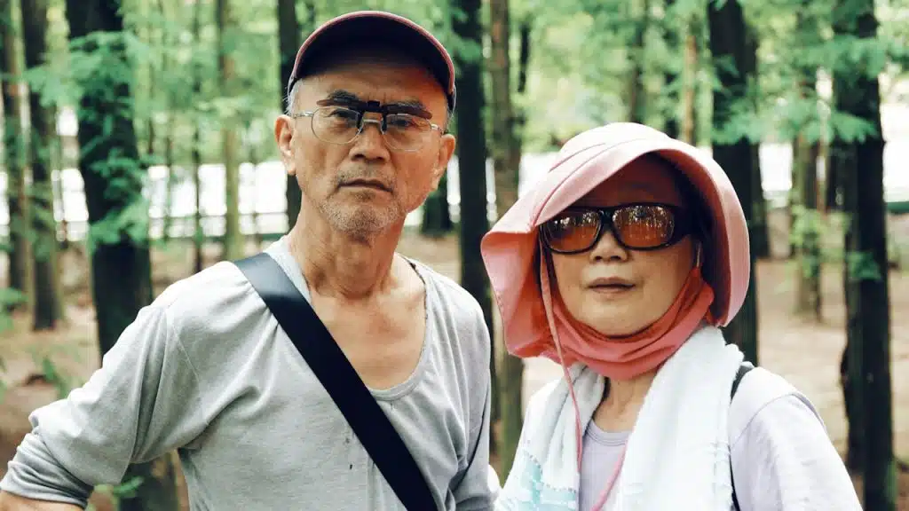 A mature couple standing in trees.