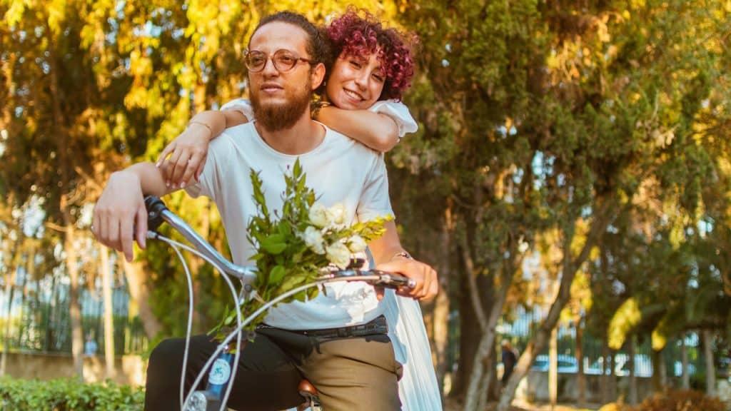 A woman sitting behind a woman riding a bike.
