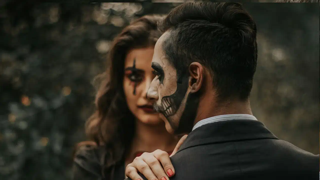 A man and a woman with Halloween paint on their faces.