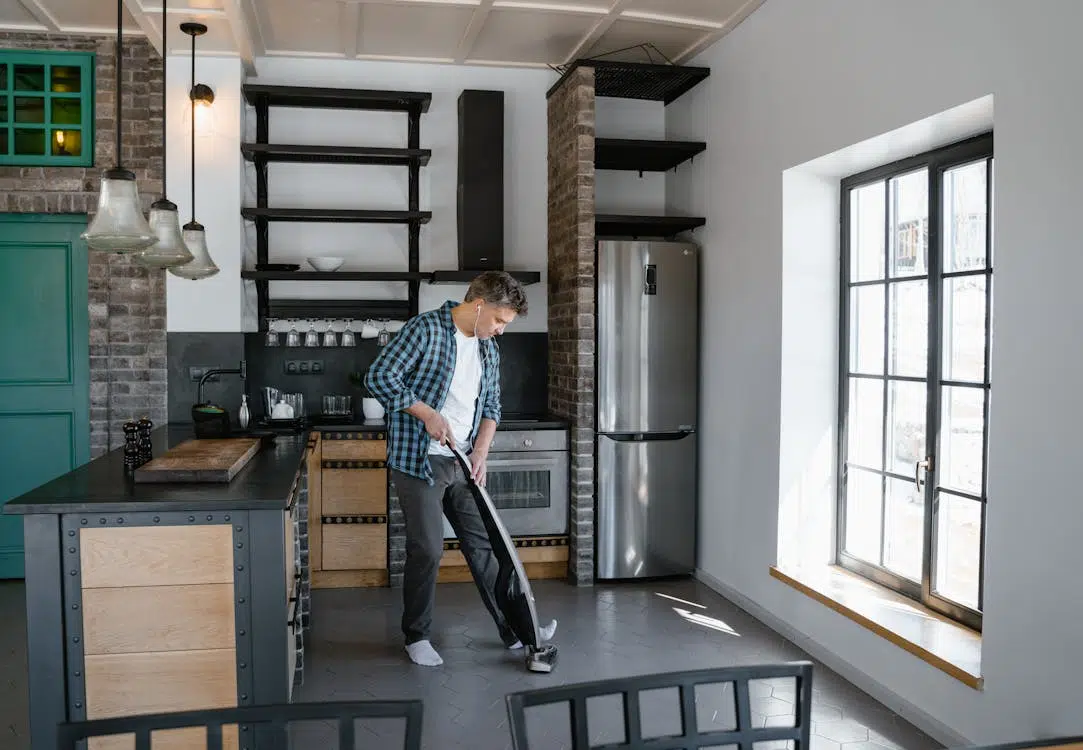 A man vacuuming the floor