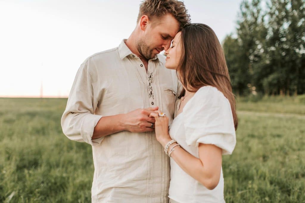 A couple standing on a field.