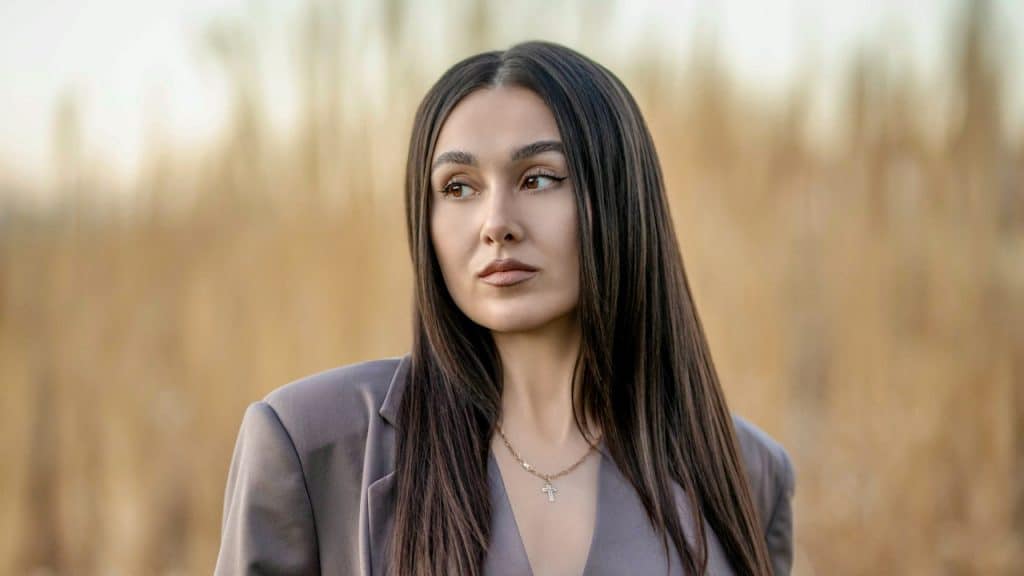A woman standing in a field of tall grass.