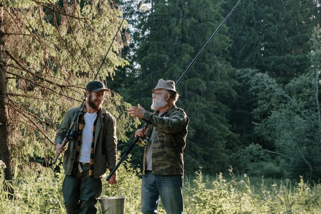 Father and son holding a bucket and fishing rods