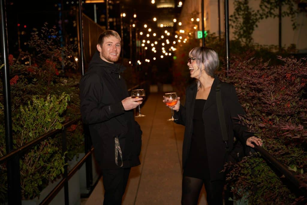 A man and a woman having wine and laughing together.