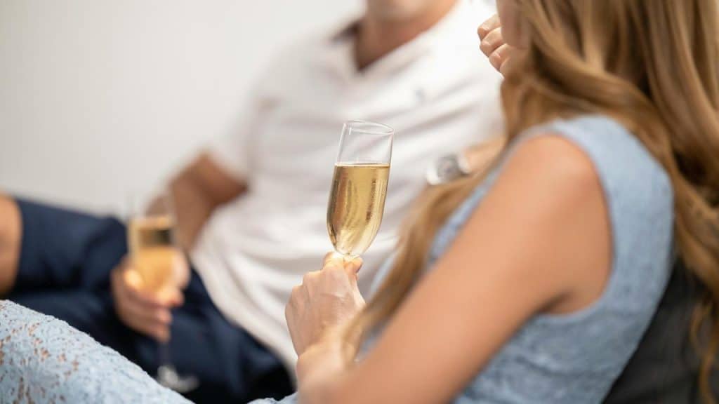 A couple holding champagne glasses while relaxing together.