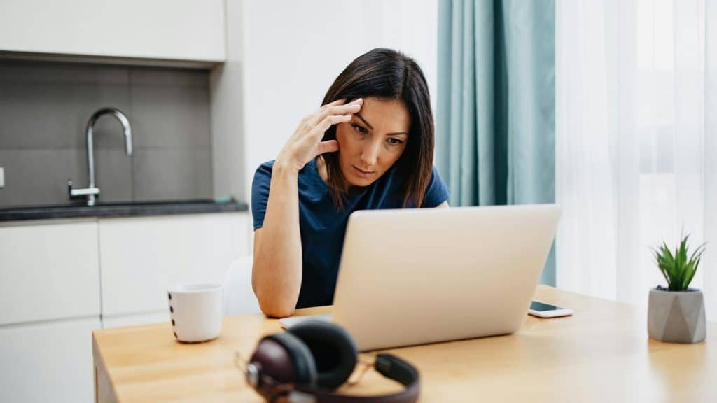 A woman working on a laptop at a table.