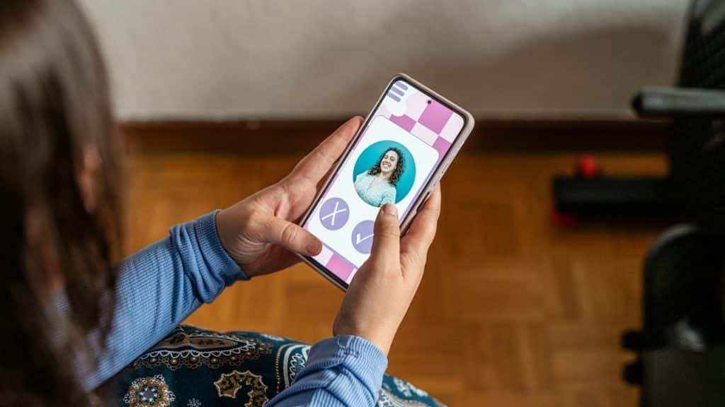 Woman swiping right on a dating app profile displayed on a smartphone.