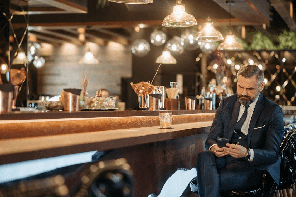 A man in a suit sitting at the bar