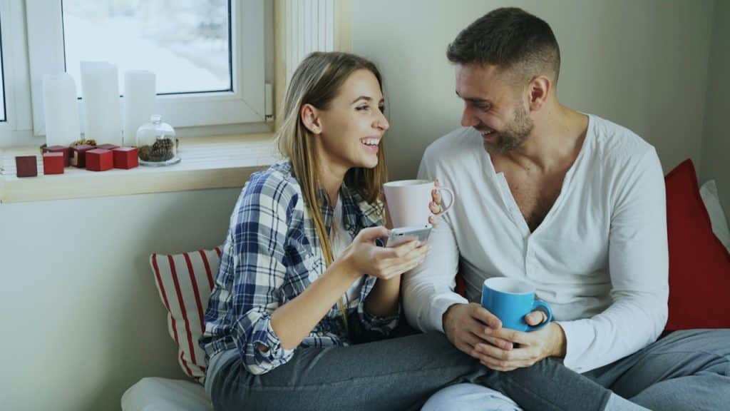 A couple enjoying coffee together by the window.