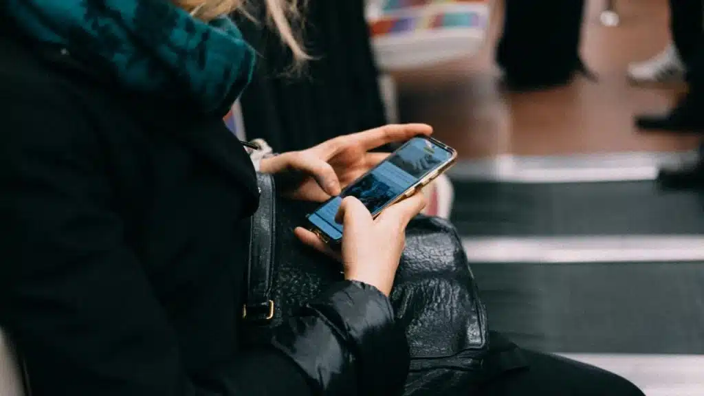A person using a smartphone while seated on public transit.
