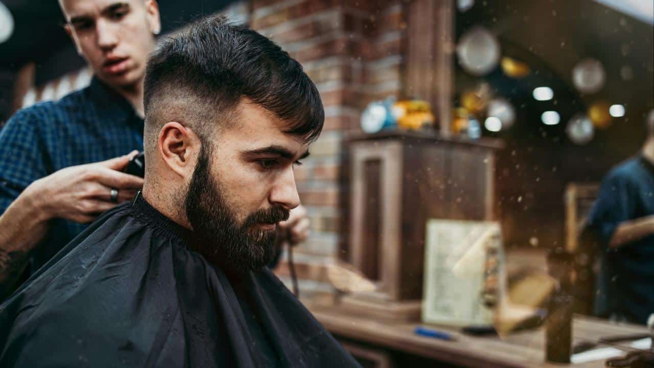 A man getting a haircut at a barbershop.