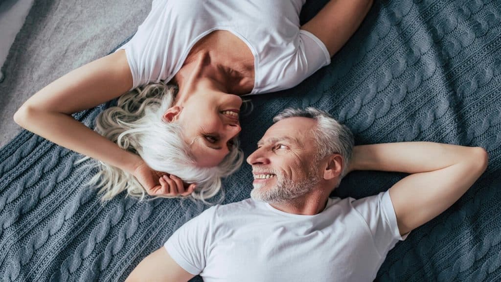 A couple looking at each other in bed