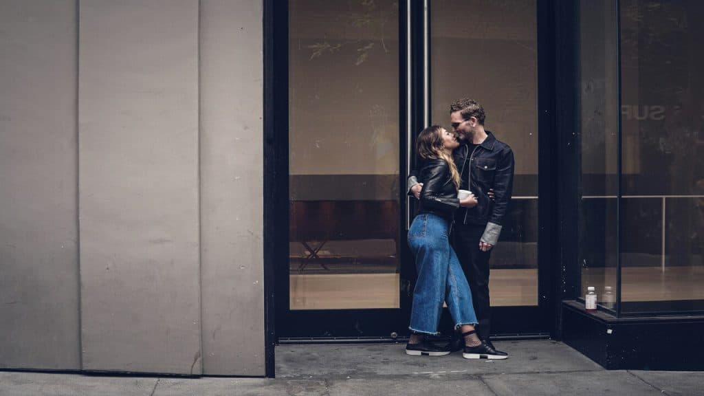 A couple kissing by the door