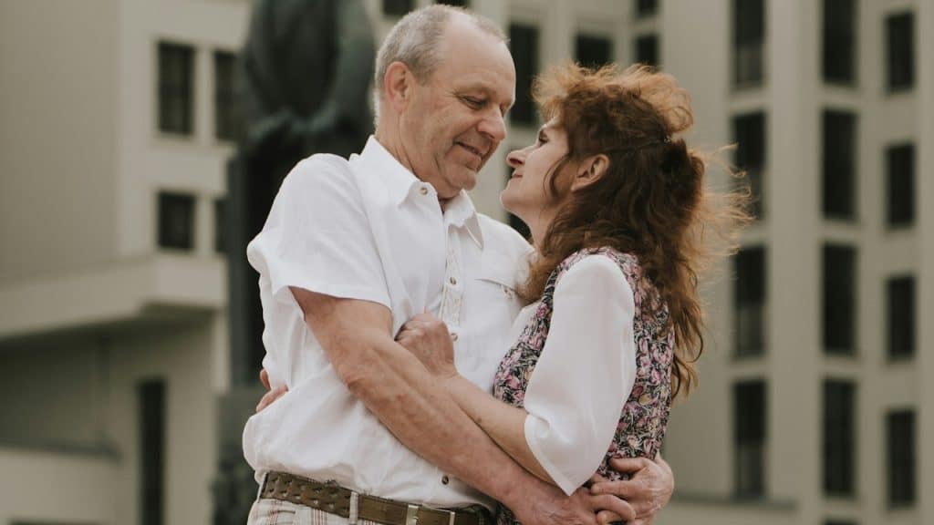 A man and a woman embracing each other in front of a building.