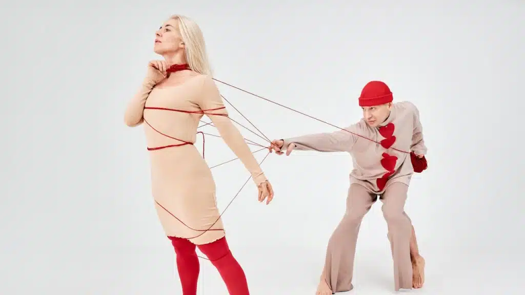 A man pulling a woman with strings.
