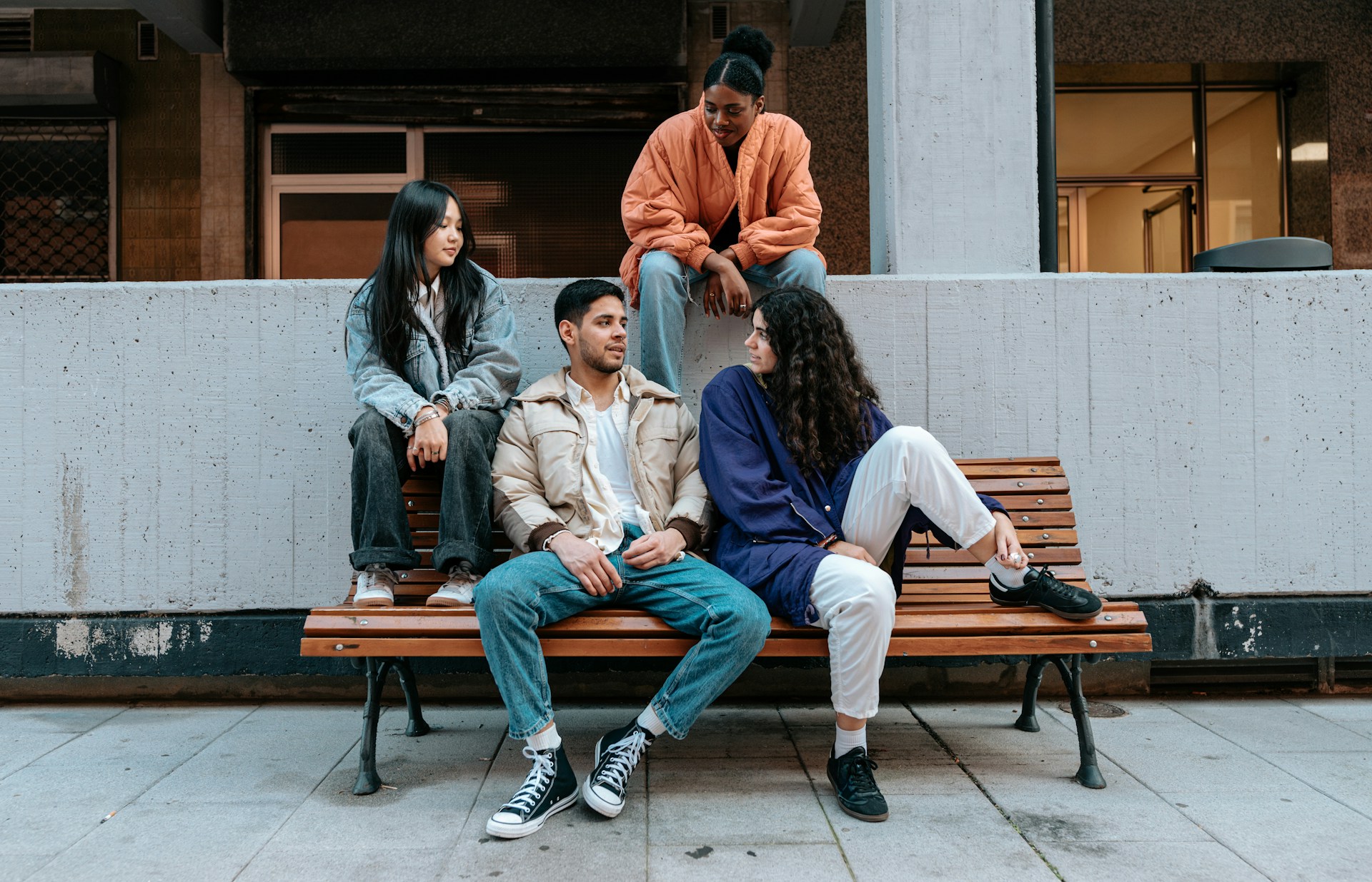 A group of friends sitting on the wooden bench.