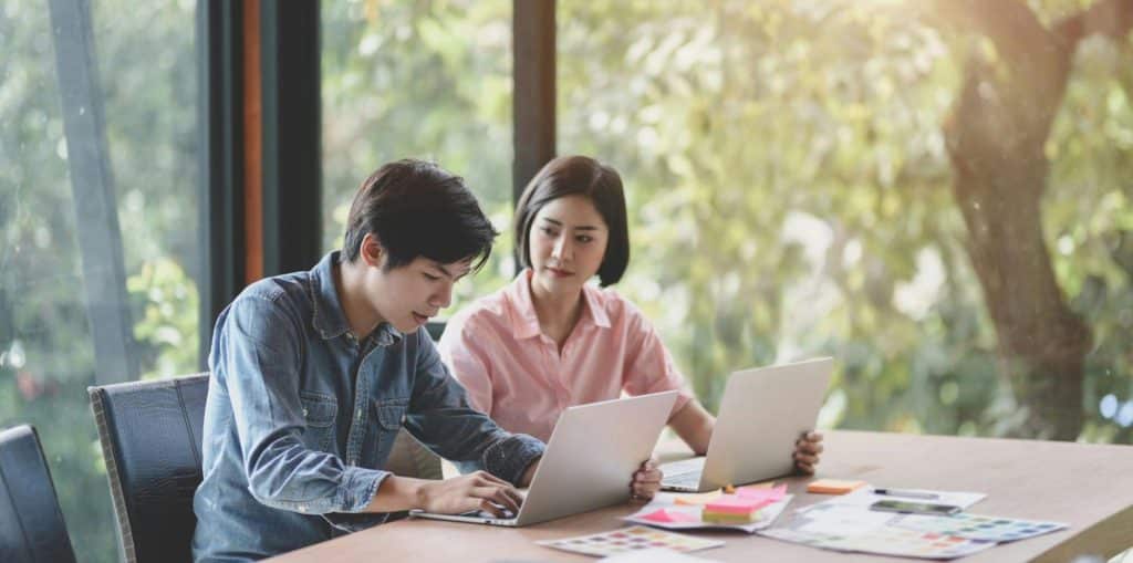 A man and woman busy with their laptops