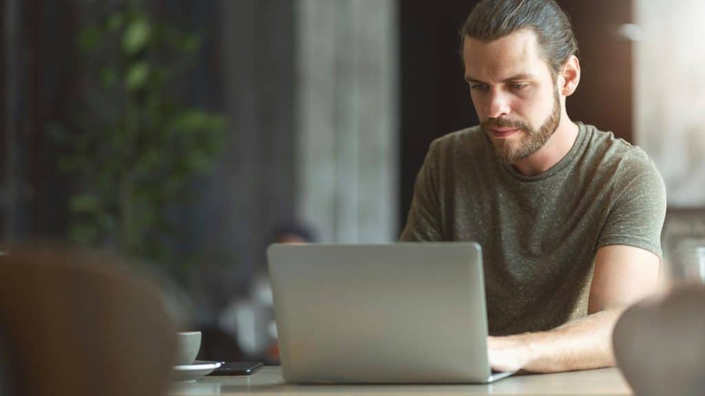 A person working on a laptop at a table.