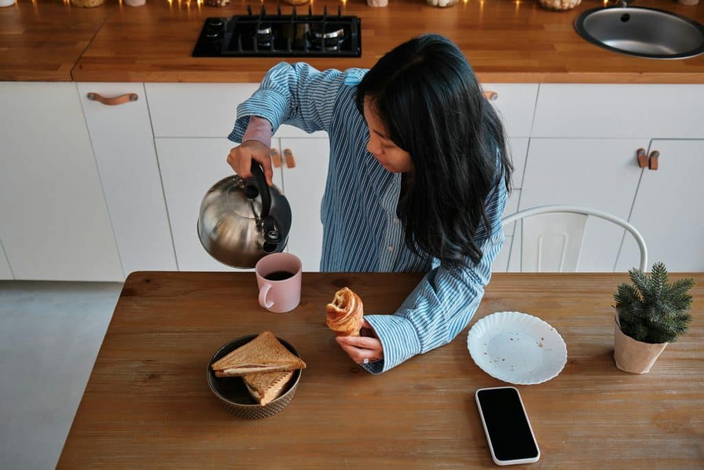 A woman pours tea into the cup.