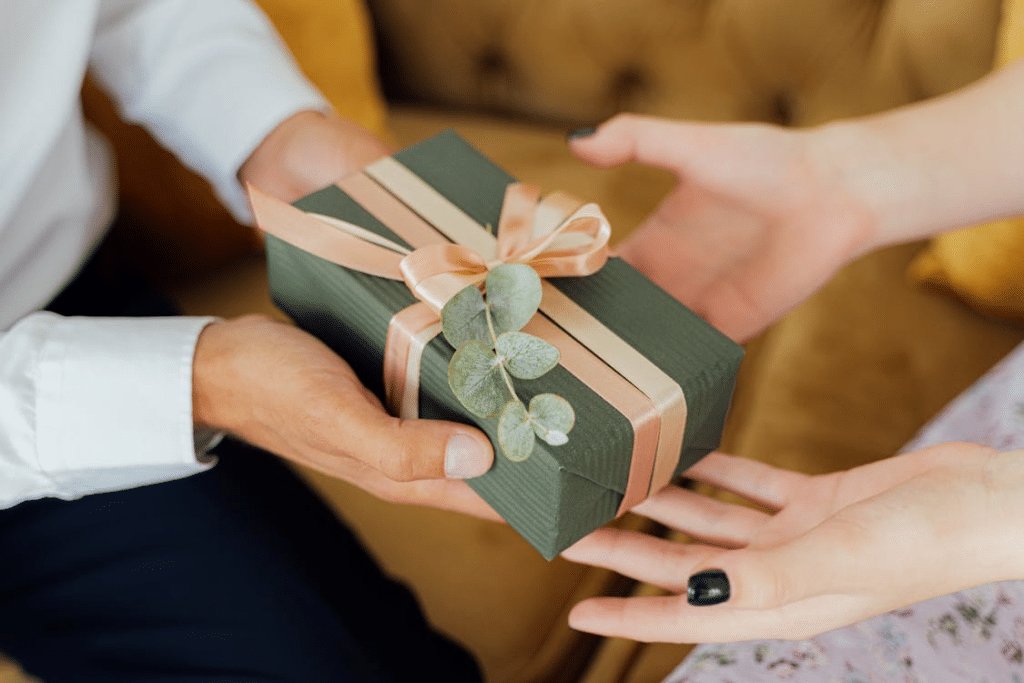 A man is giving a green box to a woman