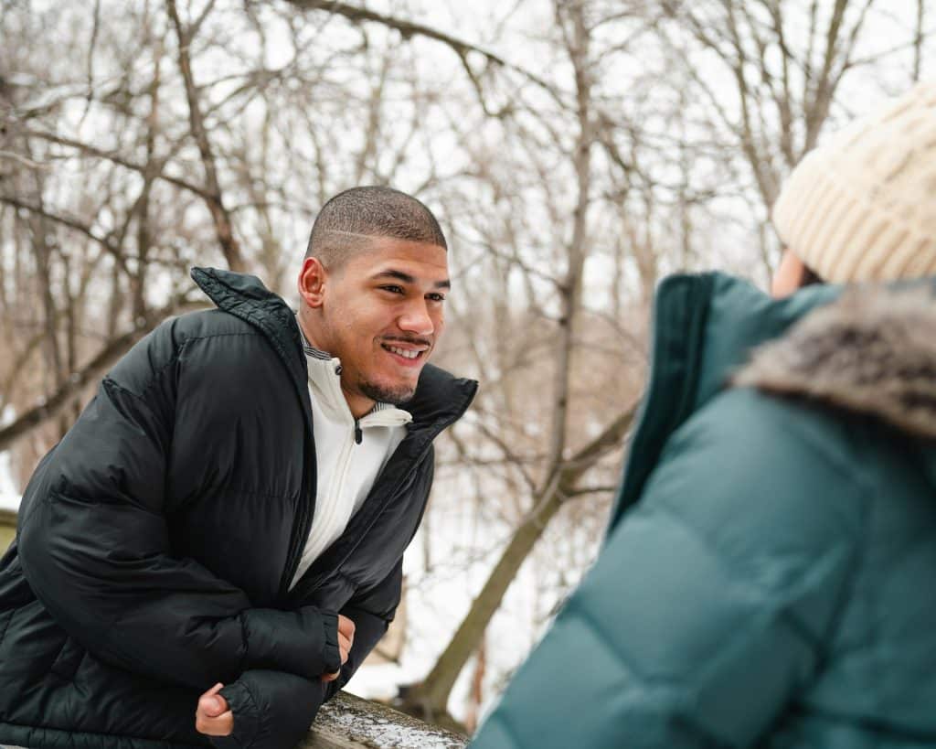 A man talking to a woman at the park.