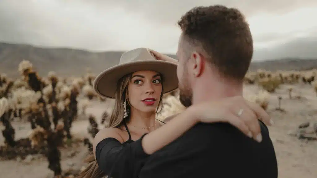 A man holding a woman in a desert.