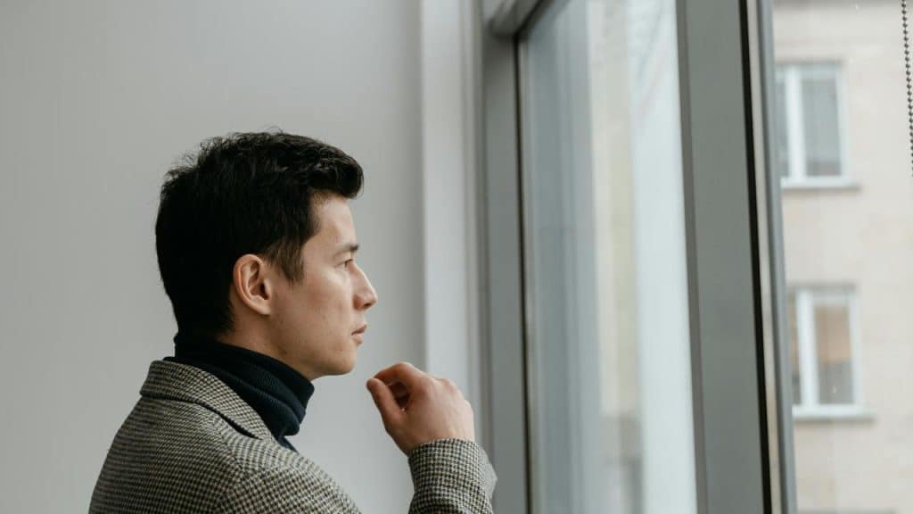 A man in a suit looking out of a window.