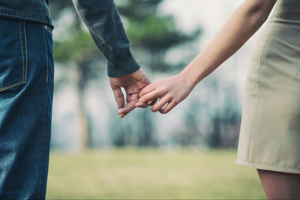 A man and woman barely holding hands