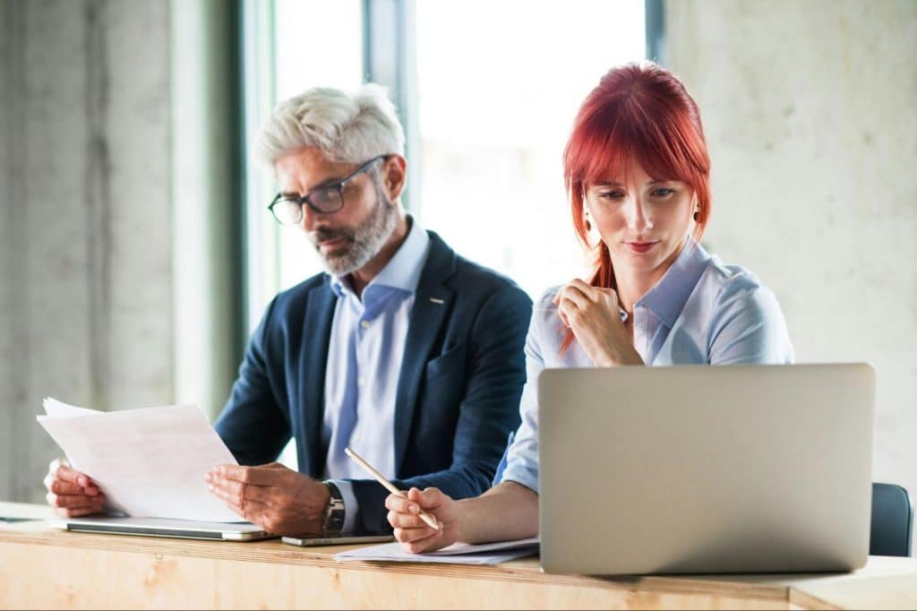 A woman just smiling and a man busy with his work