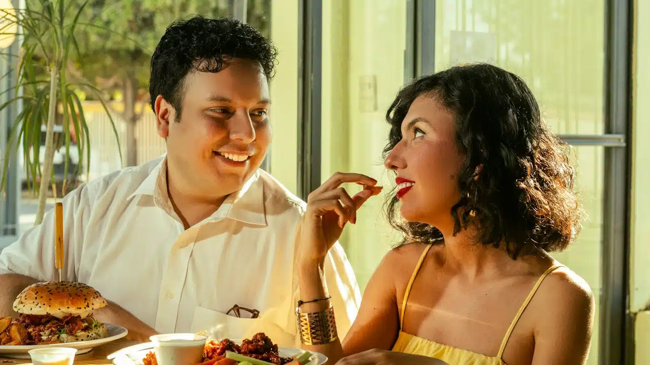 A couple shares food and laughter together in a restaurant.