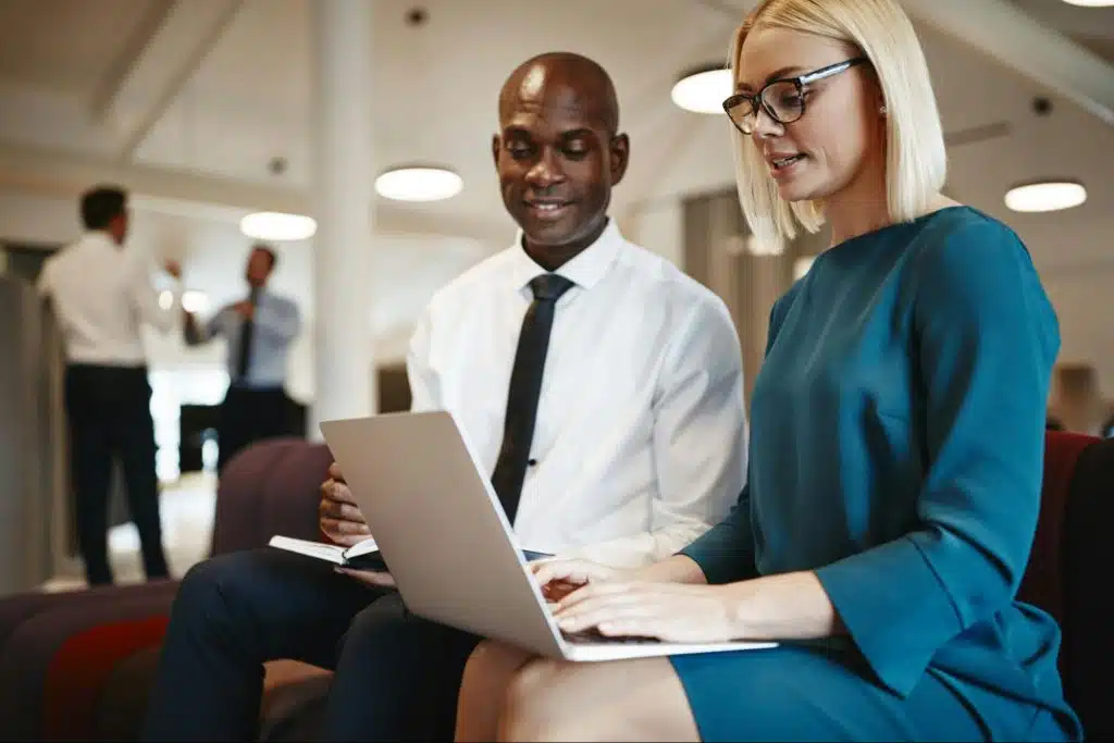 A woman getting help from a man about work