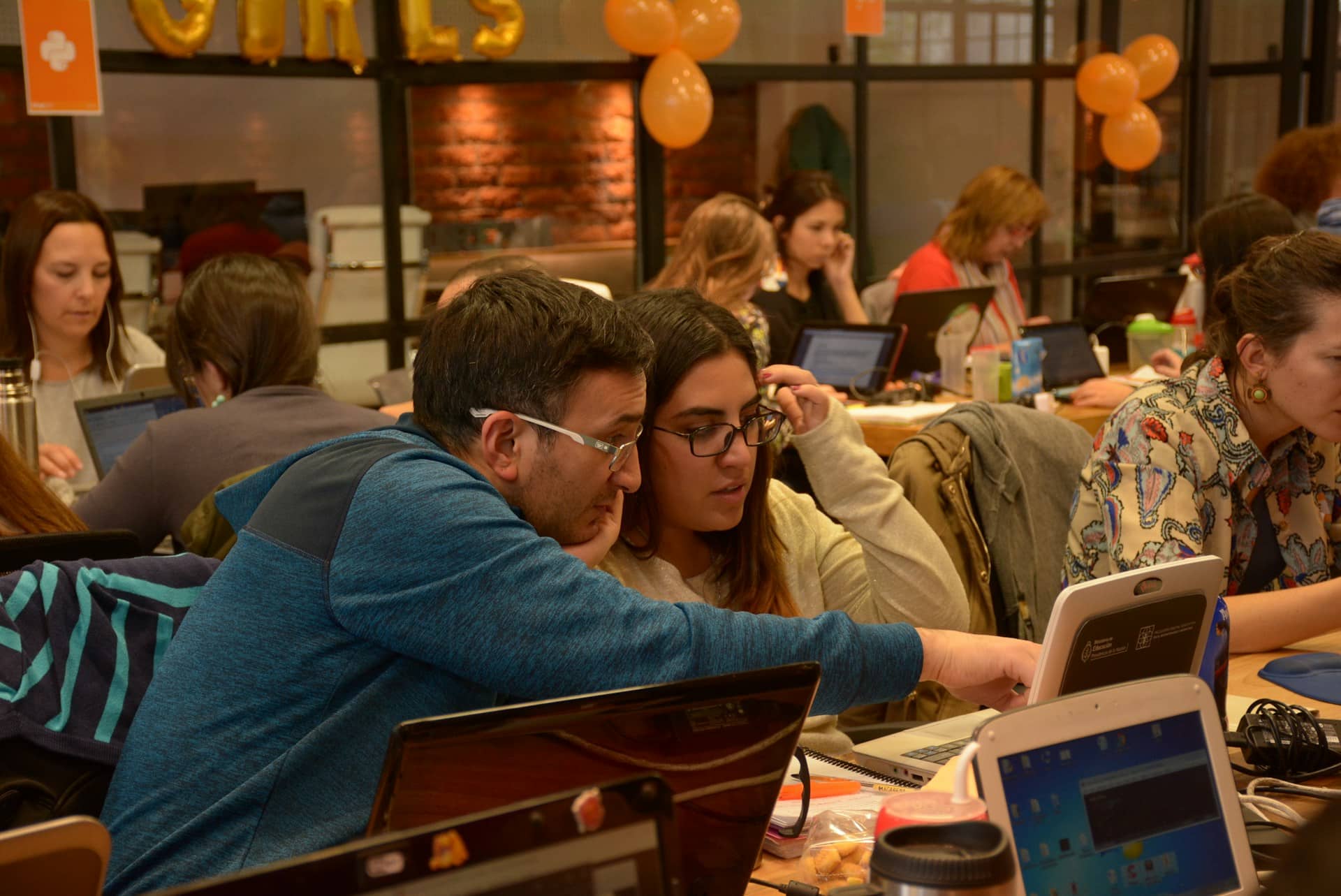 A group of people sitting at a table with laptops.