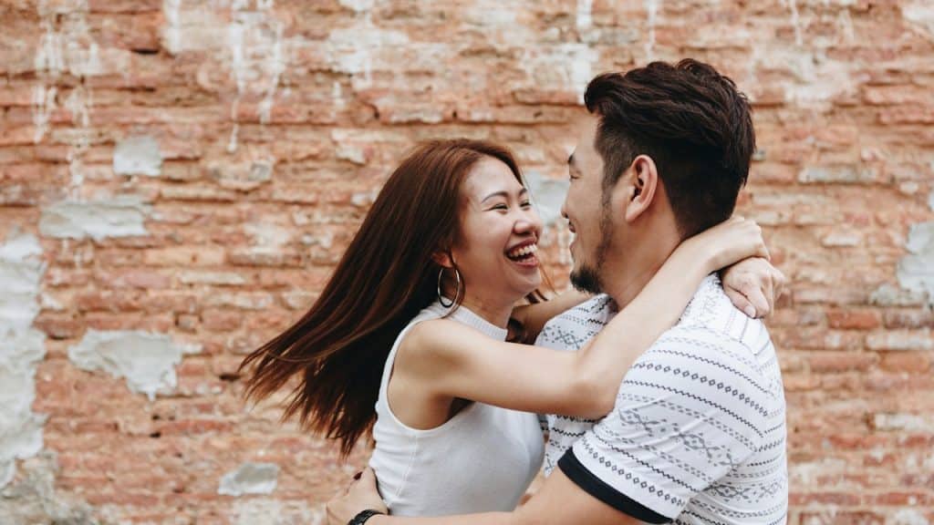 A woman hugging a man and smiling.