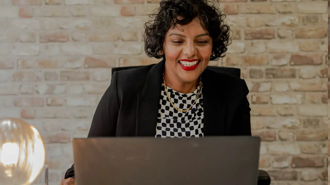 A woman is sitting in front of a laptop computer.