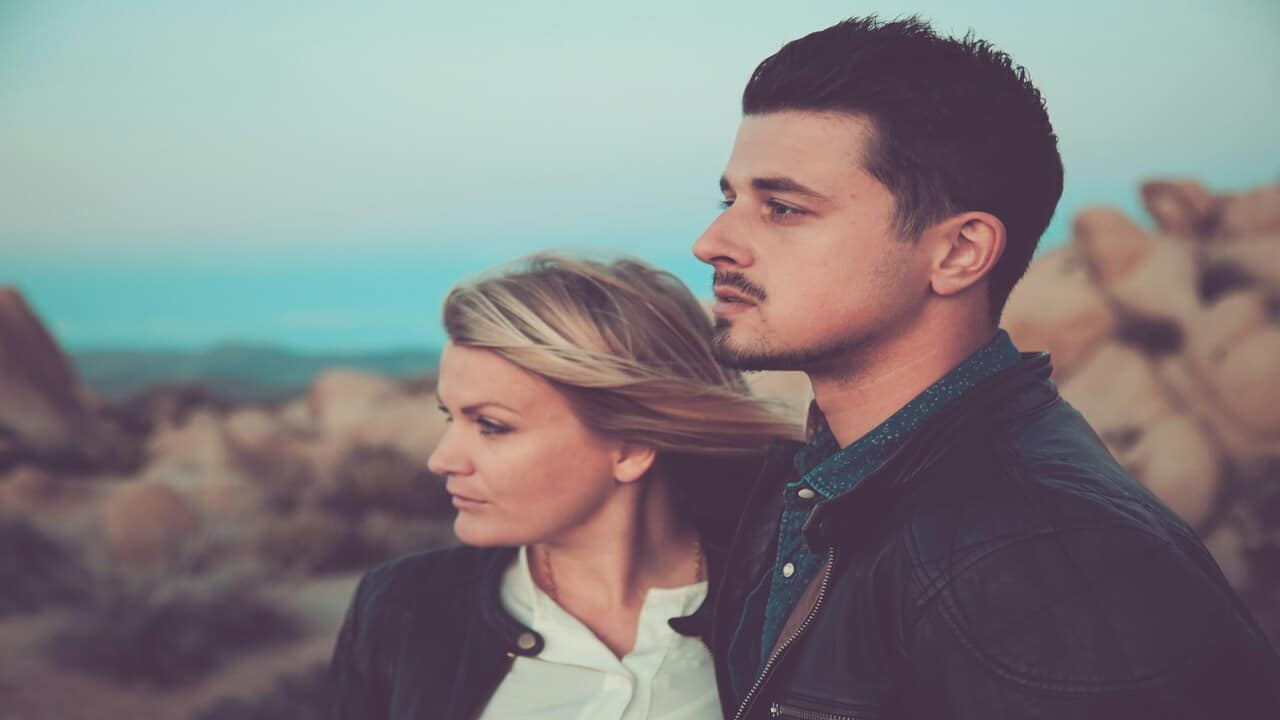 A couple looking serious while outdoors