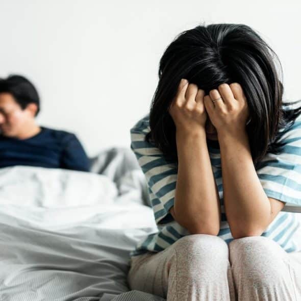 A couple sad in bed