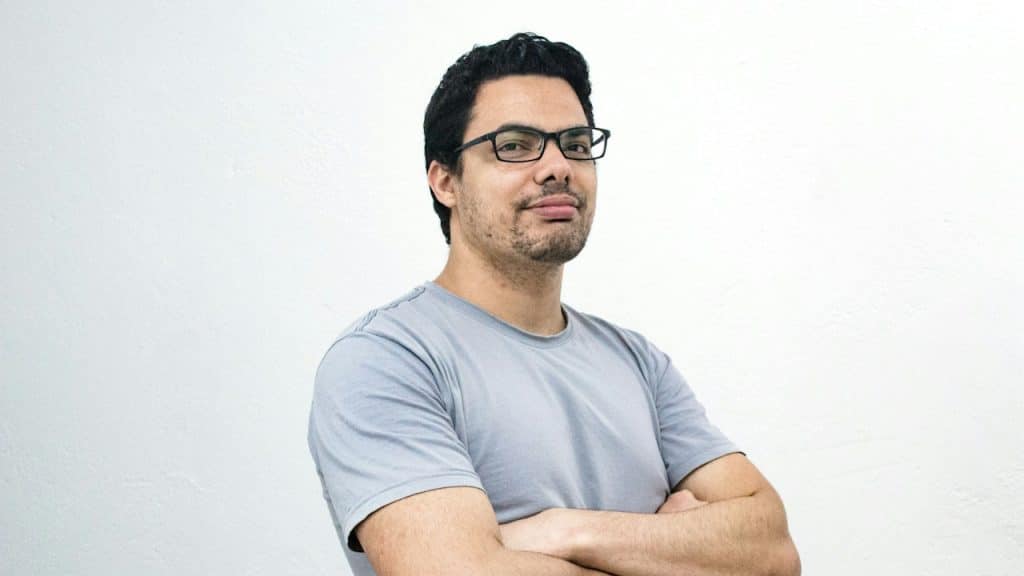A man with crossed arms is standing with a white background.