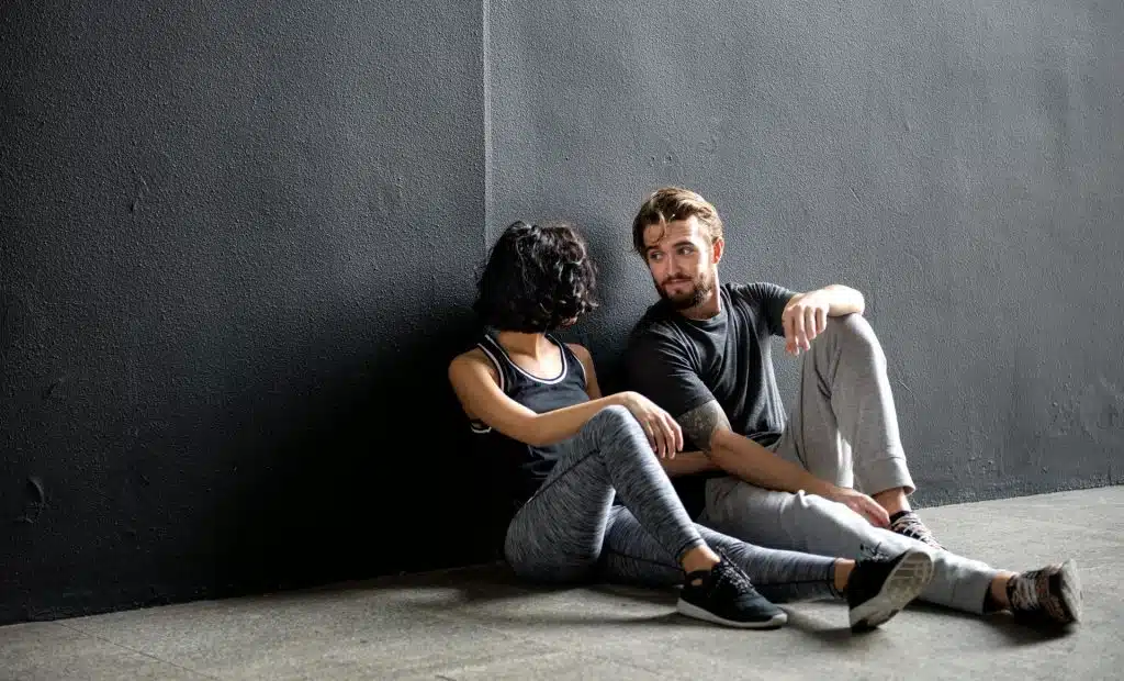 A couple in gym active wear looking at each other.