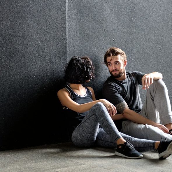 A couple in gym active wear looking at each other.