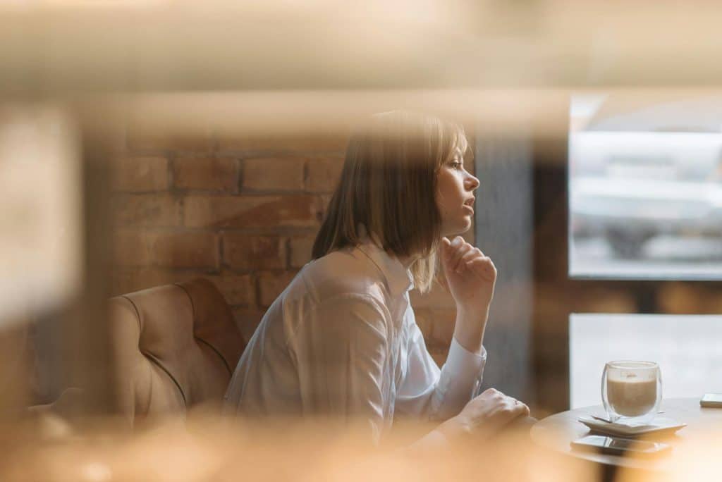 A woman talking with someone in a coffee shop.