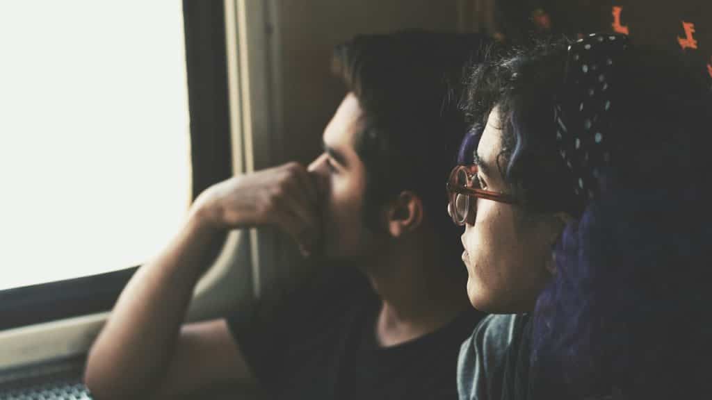 A thoughtful couple looking out of the window.