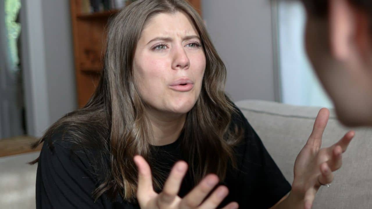 Woman with an expressive, slightly frustrated look talking and gesturing to someone.
