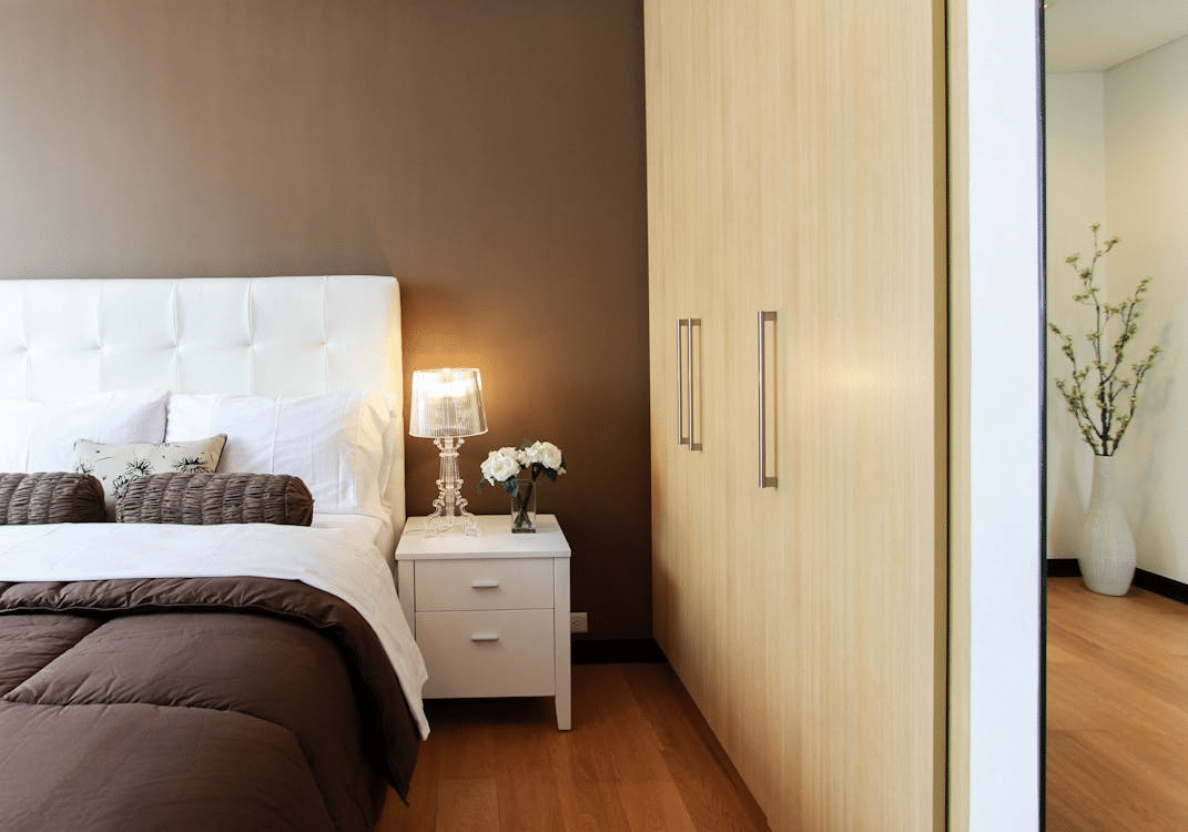 A white bed next to a white table