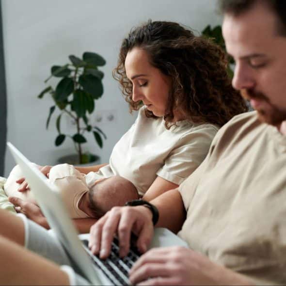 A man busy with his work and a woman carrying a baby