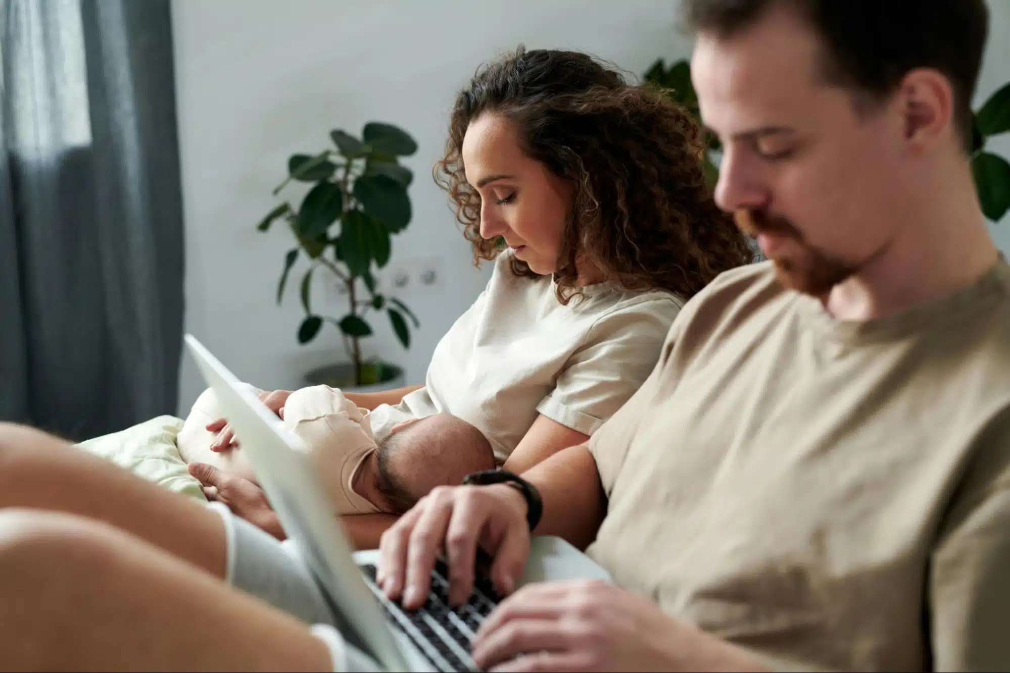 A man busy with his work and a woman carrying a baby 