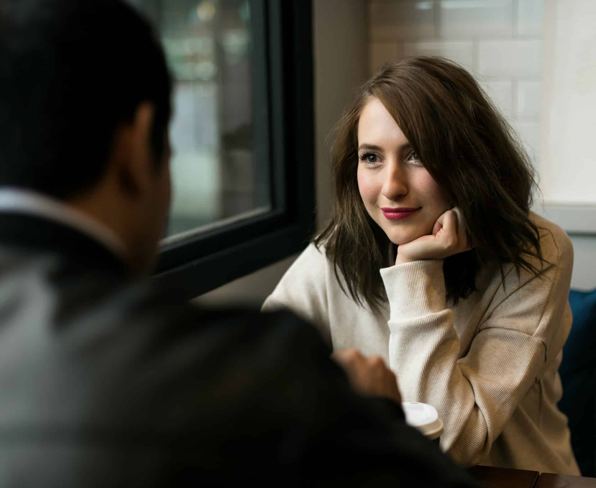 A woman lovingly looking at the man sitting across from her.