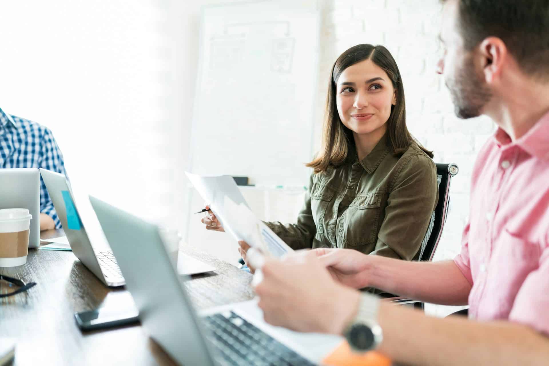 A woman looking at the man while discussing something at work.